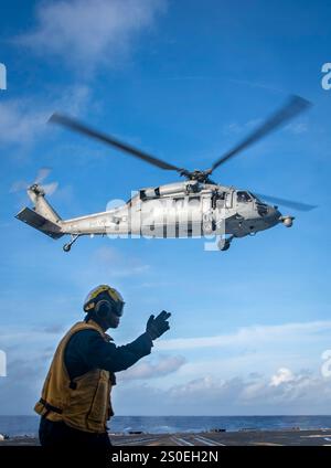 PHILIPPINE SEA (21 dicembre 2024) – il Boatswain's Mate 2nd Class K'Shaun Zeno, di Lafayette, Laos, guida un MH-60S Seahawk assegnato ai "Black Knights" dell'Helicopter Sea Combat Squadron (HSC) 4 mentre decolla dal ponte di volo a bordo del cacciatorpediniere missilistico guidato classe Arleigh Burke USS Sterett (DDG 104), 21 dicembre 2024. Il Carl Vinson Carrier Strike Group sta conducendo operazioni di routine nell'area delle operazioni della 7th Fleet degli Stati Uniti. (Foto della Marina degli Stati Uniti di Brianna Walker, specialista della comunicazione di massa di terza classe) Foto Stock