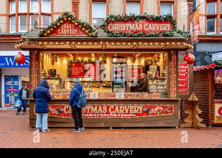 Un mercatino di Natale che vende cibo di strada su Broad Street nel centro di Reading, Berkshire, Regno Unito nel dicembre 2024. Foto Stock