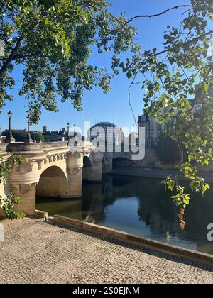 Il bellissimo Pont Neuf Bridge di Parigi a piedi la mattina presto mentre la città inizia a svegliarsi. Pace e bellezza si combinano in una mattina d'estate Foto Stock