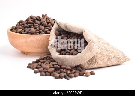 Chicchi di caffè tostati in sacco e in una ciotola di legno isolata su sfondo bianco. Foto Stock
