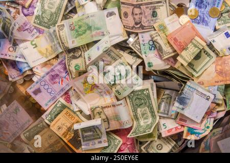 Banconote e monete internazionali in valuta estera nella scatola delle donazioni della Cattedrale di Notre Dame, Parigi, Francia. Foto Stock