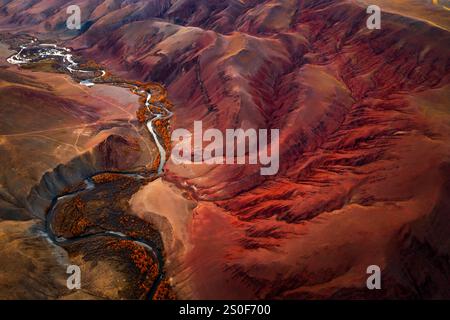 Vista aerea panoramica della ricca valle montana con tortuoso fiume e fitta foresta, che cattura vivaci sfumature autunnali, motivi erosivi, paesaggi suggestivi, che offrono uno scorcio unico di incontaminata natura selvaggia Foto Stock