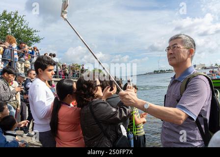 Copenaghen, Danimarca, gente affollata, turisti cinesi, uomo, visitando la statua pubblica, la Sirenetta è una statua in bronzo di Edvard Eriksen, Foto Stock