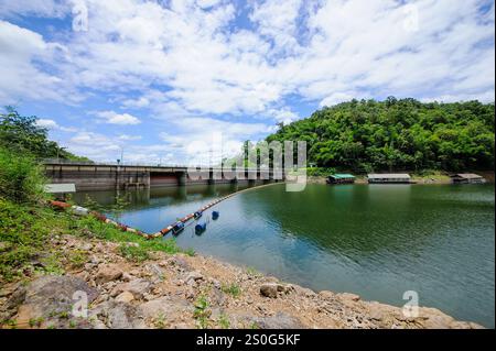 i cancelli della diga si aprono, rilasciando acqua nel fiume sottostante. L'acqua è di colore marrone fangoso, probabilmente a causa dei sedimenti trasportati dal fiume. TH Foto Stock
