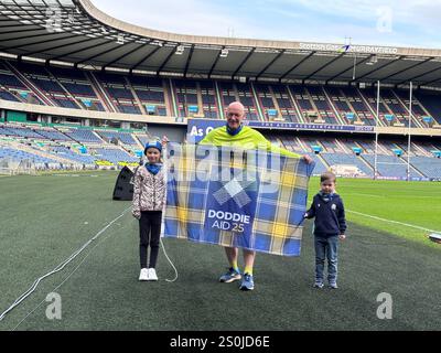 Il primo ministro scozzese John Swinney con Sienna (7, a sinistra) e Beauden (4) al Murrayfield Stadium di Edimburgo per partecipare a Doddie Aid 2025 e incontrare altri tifosi del Doddie Aid. Data foto: Sabato 28 dicembre 2024. Foto Stock