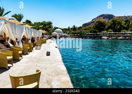 Rodi, Grecia 7 luglio 2024: Spiaggia all'interno delle sorgenti termali Kallithea (Terme Kalithea) a Rodi, Grecia. Il nuoto è un'attrazione popolare al mattino Foto Stock