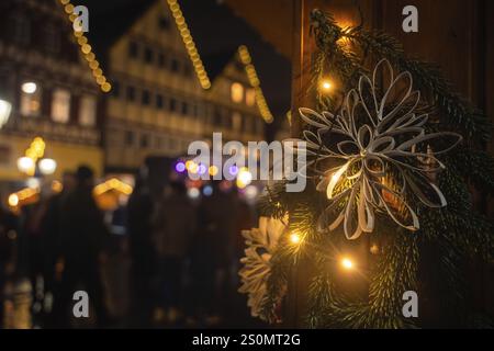 Primo piano di una decorazione natalizia di notte con le case tradizionali illuminate dietro, il mercato natalizio di vitello, la Foresta Nera, la Germania, l'Europa Foto Stock