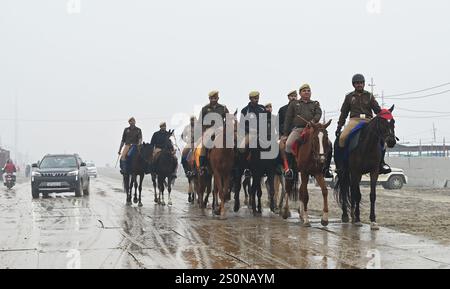 PRAYAGRAJ, INDIA - DICEMBRE 28: I poliziotti a cavallo pattugliano a Mahakumbh Nagar in vista dell'imminente Mahakumbh-2025 il 28 dicembre 2024 a Prayagraj, India. Il prossimo Maha Kumbh Mela si svolgerà a Prayagraj dal 13 gennaio al 26 febbraio 2025. Si prevede che il festival attirerà oltre 400 milioni di pellegrini. Crediti: SIPA USA/Alamy Live News Foto Stock