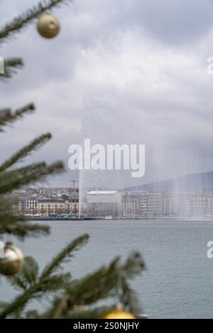 Decorazioni sull'albero di Natale che incorniciano la fontana a getto d'acqua sul lago di Ginevra in Svizzera a dicembre Foto Stock