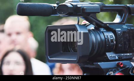 Videografo che cattura i momenti più preziosi dei bambini durante il primo giorno di scuola con una videocamera top di gamma Foto Stock