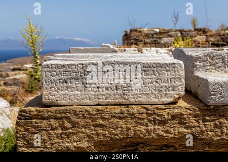Antico frammento di pietra inciso nel sito archeologico costiero di Delo, Grecia Foto Stock