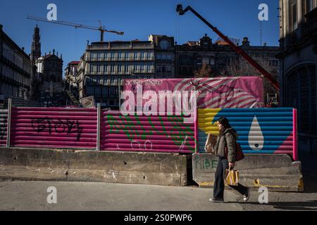 Porto, Portogallo. 20 dicembre 2024. Una donna passa nel cantiere per la nuova linea rosa della metropolitana di Porto, in viale Aliados. Sono in corso lavori per la nuova linea rosa della metropolitana di Porto nel centro della città, in Aliados Avenue, a Porto, Portogallo. (Foto di Telmo Pinto/SOPA Images/Sipa USA) credito: SIPA USA/Alamy Live News Foto Stock