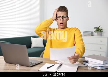 Studente emotivo che soffre di stress prima dell'esame al tavolo al chiuso Foto Stock