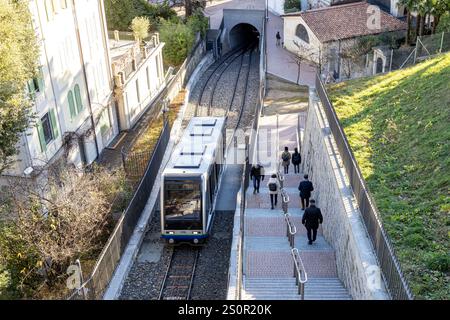 Lugano, Svizzera - 24 dicembre 2024: Una funicolare viaggia a fianco dei pedoni su una scala nella panoramica città di Lugano Foto Stock