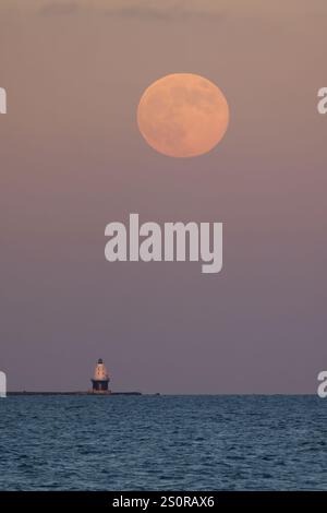 Luna piena che si innalza sul porto del Rifugio Light e barca, Lewes, Delaware Foto Stock