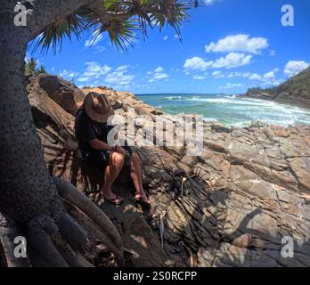 Riposa all'ombra di una palma Pandanus, Noosa National Park, Queensland, Australia. No MR Foto Stock