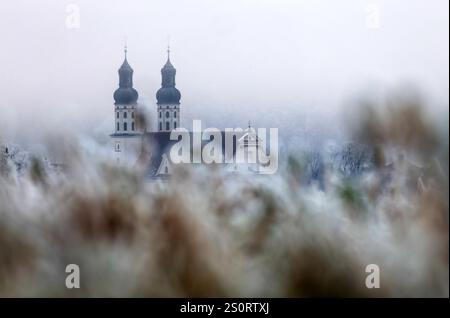 Obermarchtal, Germania. 29 dicembre 2024. Si è formata una fitta nebbia intorno a San Pietro e Paolo Minster sul Danubio. Crediti: Thomas Warnack/dpa/Alamy Live News Foto Stock