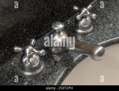 Rubinetto cromato brillante su un lavandino del bagno. Primo piano del miscelatore del rubinetto d'acqua Vintage acqua calda fredda in bagno, usalo come sfondo, Post Foto Stock
