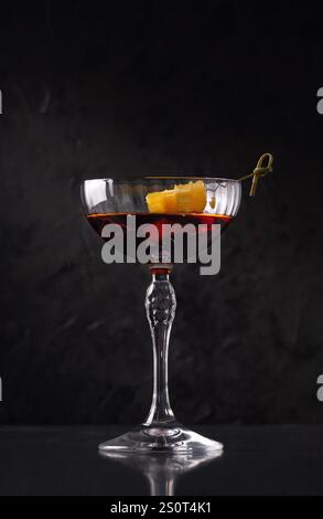 Martini - Rosso, cocktail drink con arancia su sfondo minimalista. Minimalista creativo, concetto di cibo. Su sfondo di pietra scura Foto Stock