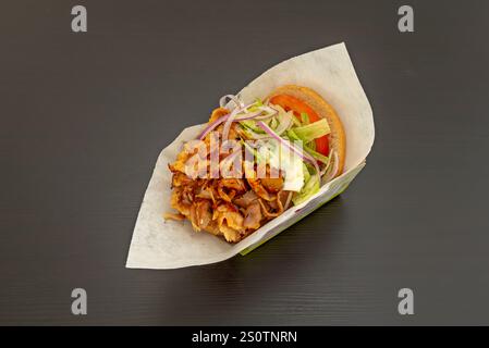 i cuochi di carne, le strisce sottili vengono tagliate e servite in una pita di pane con verdure, yogurt, salse piccanti e altri condimenti Foto Stock