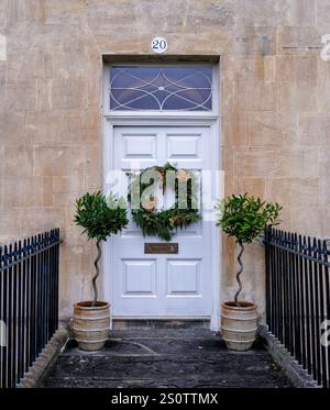 Corona di Natale sull'elegante porta d'ingresso di una casa sulla Royal Crescent a Bath, Somerset, Regno Unito Foto Stock
