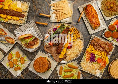 la carne viene tagliata a fette sottili e servita in una pita di pane insieme a insalate fresche, salse cremose e vari contorni Foto Stock