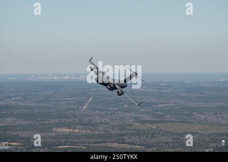 Un C-17 Globemaster III assegnato al 437th Airlift Wing vola sopra North Auxiliary Airfield, Carolina del Sud, 17 gennaio 2024. Il 437esimo AW ex Foto Stock