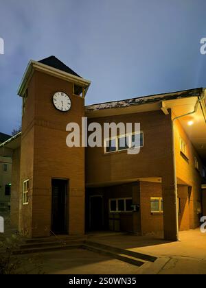 Vecchia casa in mattoni con una torre dell'orologio in una strada residenziale a Denver, Colorado, di notte Foto Stock
