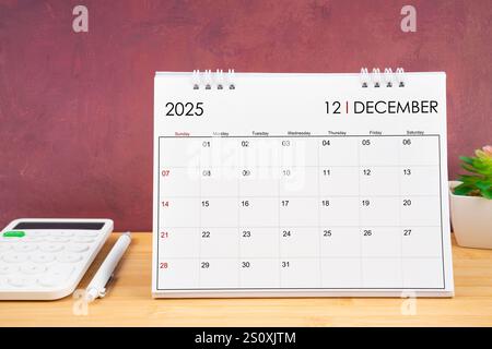 Dicembre 2025 calendario bianco e calcolatrice con penna sul tavolo. Foto Stock