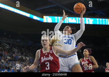 L'attaccante degli UCLA Bruins Timea Gardiner (30) lancia la palla contro la guardia dei Nebraska Cornhuskers Allison Weidner (3) nel secondo tempo durante una partita di basket universitaria femminile al Pauley Pavilion, domenica 29 dicembre 2024, a Los Angeles. Foto Stock