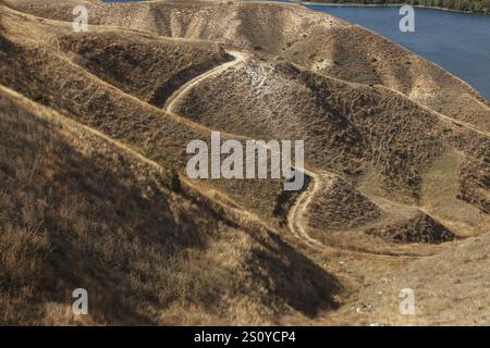 Colline ondulate e sentieri tortuosi circondano le tranquille acque del lago artificiale Shamb nella provincia di Syunik, Armenia, creando un paesaggio pittoresco. Foto Stock