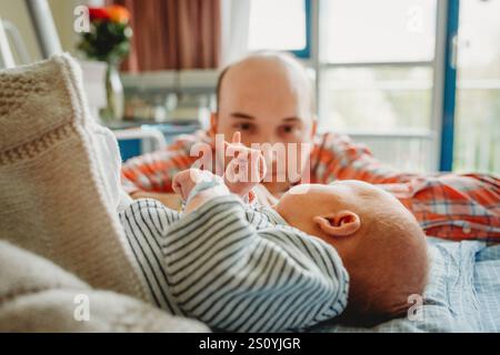 Padre padre che guarda neonato bambino che dorme in ospedale Foto Stock