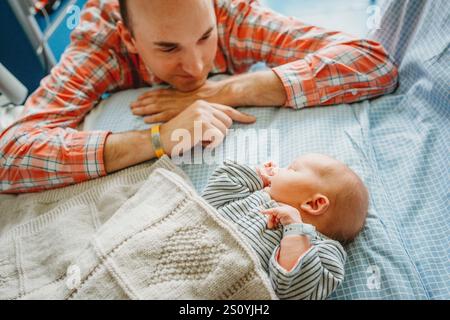 Padre padre che guarda neonato bambino che dorme in ospedale Foto Stock