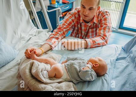 Padre padre che guarda neonato bambino che dorme in ospedale Foto Stock