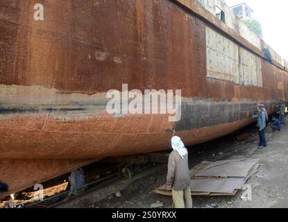 Uomini del Bangladesh che lavorano su navi nei cantieri navali vicino al fiume Buriganga a Dacca, Bangladesh. Foto Stock