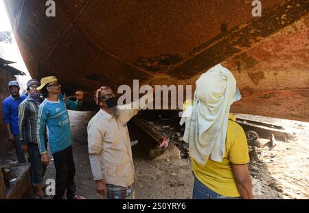 Uomini del Bangladesh che lavorano su navi nei cantieri navali vicino al fiume Buriganga a Dacca, Bangladesh. Foto Stock