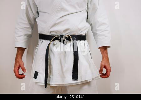 Karateka irriconoscibile con cintura nera. Foto Stock