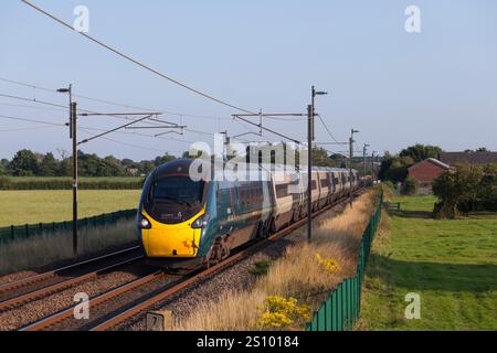 Avanti West Coast classe 390 Alstom Pendolino train 390045 sulla linea ferroviaria elettrificata della costa occidentale passando per Brock, Lancashire Foto Stock