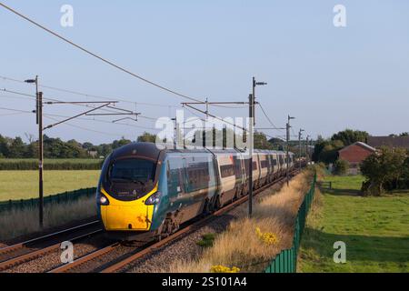 Avanti West Coast classe 390 Alstom Pendolino train 390045 sulla linea ferroviaria elettrificata della costa occidentale passando per Brock, Lancashire Foto Stock