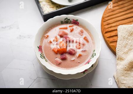 Il bububur Cha Cha è un cremoso dessert al cocco con cubetti colorati di patate dolci viola, arancia e bianca e igname. Foto Stock