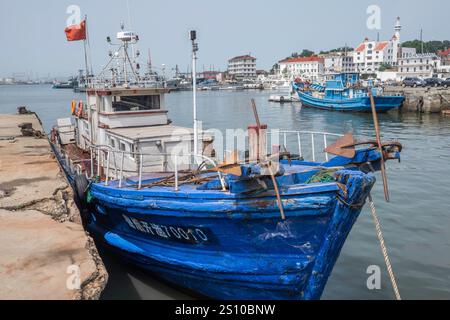 Cina, Yantai, 2015-06-11, barca, porto, barca di legno, pesca, bandiera cinese, scafo blu, mare Foto Stock