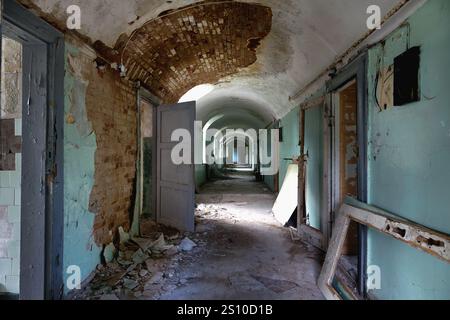 Corridoio con porte aperte in un vecchio ospedale psichiatrico abbandonato Foto Stock