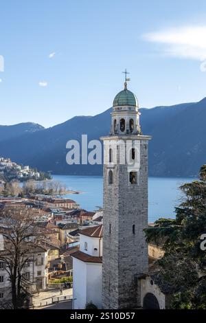 Lugano, Svizzera - 24 dicembre 2024: Vista sulla torre del Duomo con il lago e le montagne Foto Stock