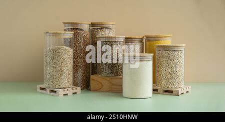 Vaso in vetro ricaricabile con porridge a grana cruda. Spazio di copia ricarica formato prodotto ecologico. Riempimento del contenitore riutilizzabile di specie intere di grani di farro. Ingrediente alimentare vegano ricco di fibre ad alto contenuto proteico. Superfood senza glutine cibo sano nutrizionale dietetico alternativo Foto Stock