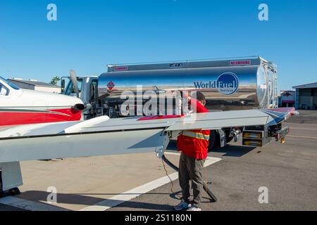 Uomo che fa rifornimento di un piccolo aereo privato in un aeroporto in Arizona Foto Stock