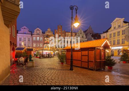 Decorazioni natalizie illuminate e bancarelle in legno nella Piazza del mercato Vecchio di Poznan, Polonia Foto Stock