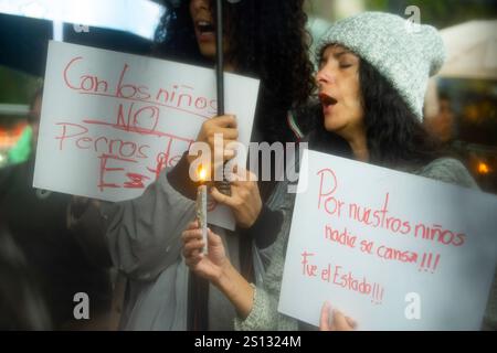 Quito, Ecuador. 30 dicembre 2024. Un manifestante tiene in mano un cartello e una candela accesa durante la dimostrazione. Le piogge sono arrivate e sono trascorsi 22 giorni dalla scomparsa dei quattro bambini di Las Malvinas, a Guayaquil. Decine di persone continuano a scendere in strada per manifestare pacificamente, chiedendo allo Stato di restituirli vivi. Credito: SOPA Images Limited/Alamy Live News Foto Stock