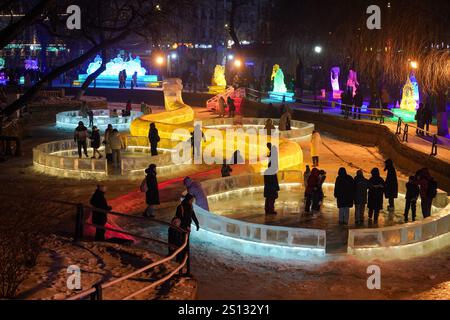 Harbin, Cina. 30 dicembre 2024. Le persone visitano lanterne di ghiaccio illuminate e sculture di ghiaccio alla 51a Harbin Ice Lantern Art Fair il 30 dicembre 2024 ad Harbin, nella provincia cinese di Heilongjiang. Crediti: Zhao Yuhang/China News Service/Alamy Live News Foto Stock