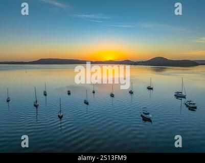 Alba sull'acqua di Brisbane, con cieli prevalentemente limpidi e una piccola nuvola luminosa alta intorno al Couche Park, Koolewong sulla costa centrale, NSW, Australi Foto Stock
