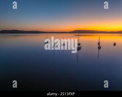 Alba sull'acqua di Brisbane, con cieli prevalentemente limpidi e una piccola nuvola luminosa alta intorno al Couche Park, Koolewong sulla costa centrale, NSW, Australi Foto Stock